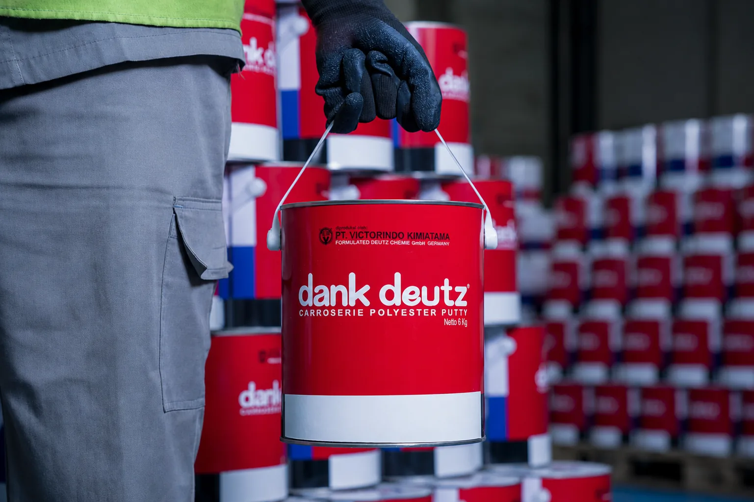 Dank Deutz Carroserie Polyester Putty pail held by a VK warehouse operator