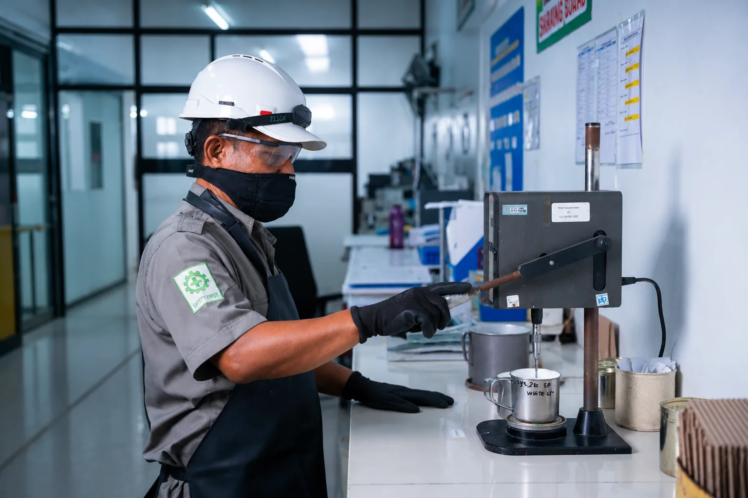 QC technician running a viscosity test on a Krebs viscometer